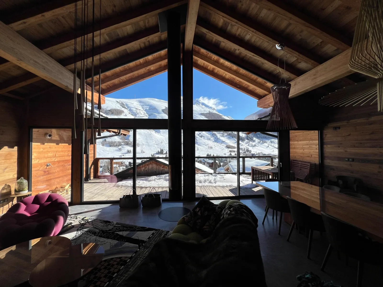 Vue sur les massifs enneigés depuis un séjour aux vitres impeccables, dans la région grenobloise